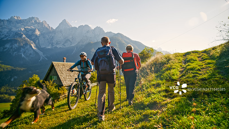 活跃的老年夫妇在乡村小径上徒步旅行和骑山地自行车图片素材