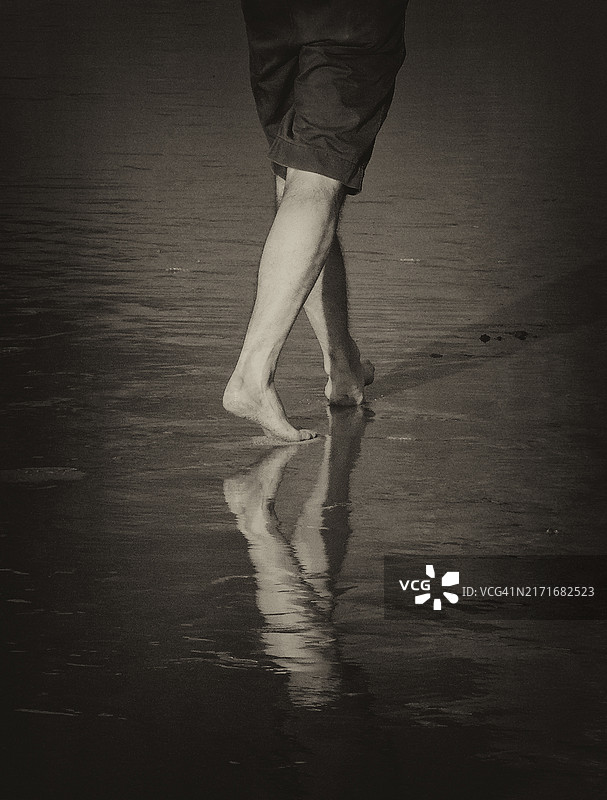 在沙滩湿沙上行走的赤脚图片素材