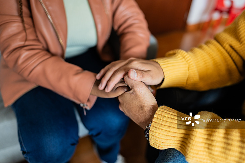治疗师在治疗过程中握住患者的手以安慰他们的特写镜头图片素材