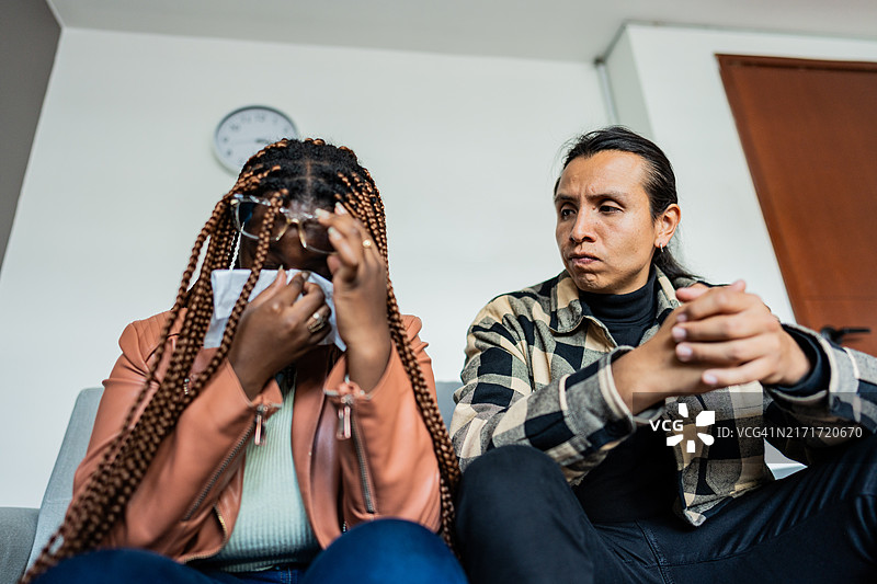 丈夫在诊所的治疗会议上安慰哭泣的妻子图片素材