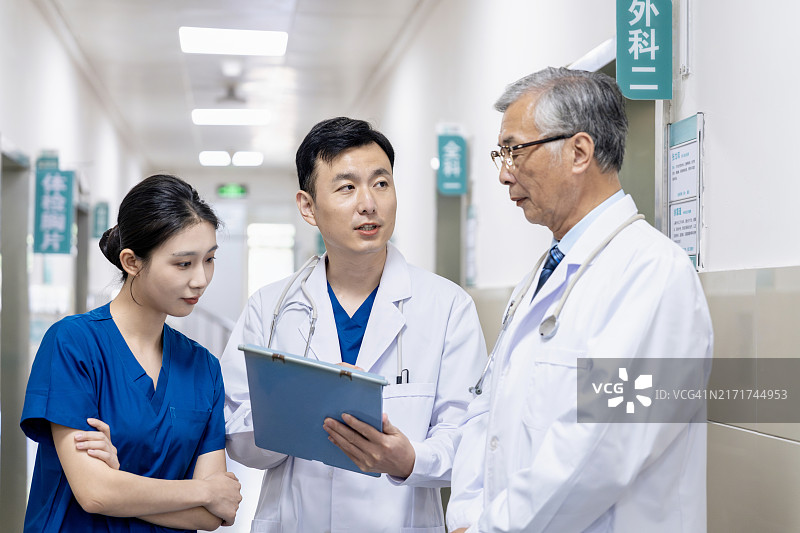 亚洲医生和护士在医院走廊讨论文件图片素材
