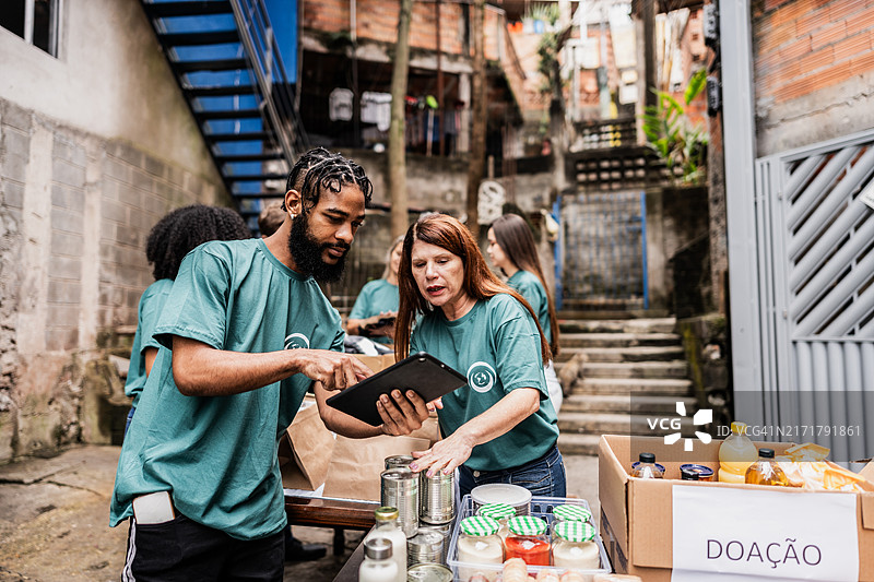 志愿者在户外捐赠时使用平板电脑图片素材