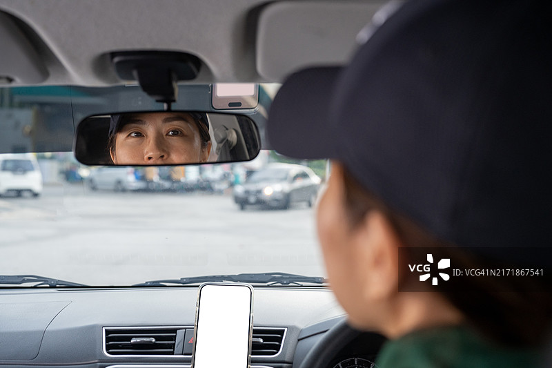 一位亚洲华裔女性司机系着安全带驾驶她的汽车的肖像图片素材