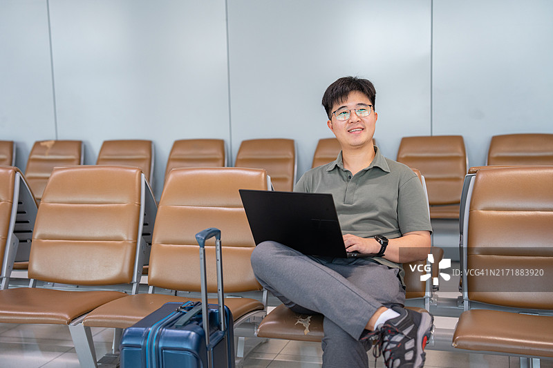 一名商人在机场大厅的长椅上工作图片素材