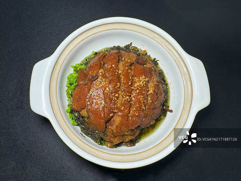 黑色背景上的美味猪肉红烧菜肴图片素材