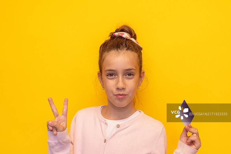 青少年女孩撅嘴并用手指比出数字二图片素材