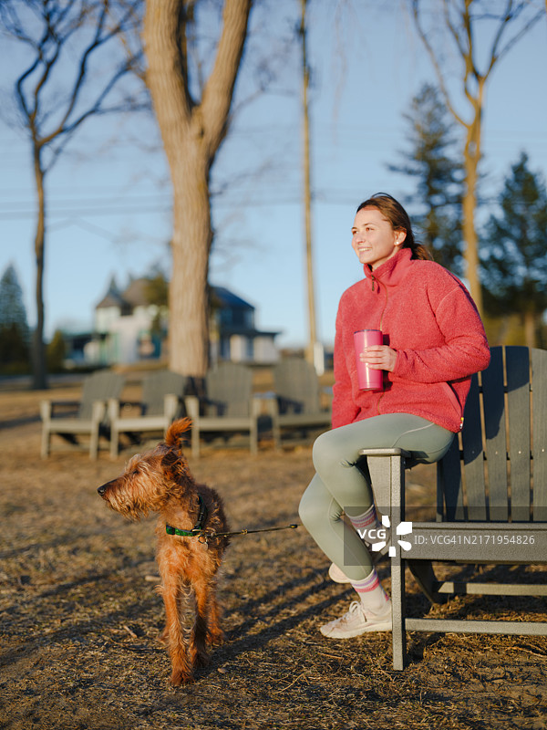 女子在森林中遛狗，享受宁静图片素材