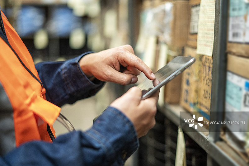操作员在五金店使用数字平板电脑的手部特写图片素材