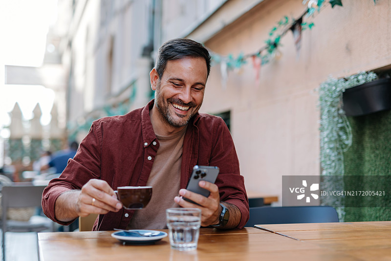 男人在户外喝咖啡时使用智能手机图片素材