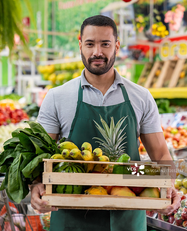 市场摊贩在蔬菜店拿着一篮子杂货图片素材