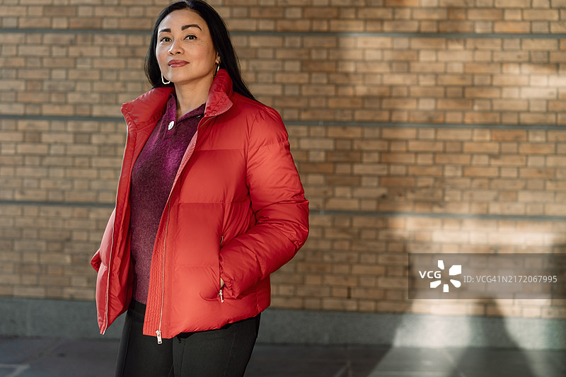 一位身穿红色羽绒服的亚洲女性在伦敦街头图片素材