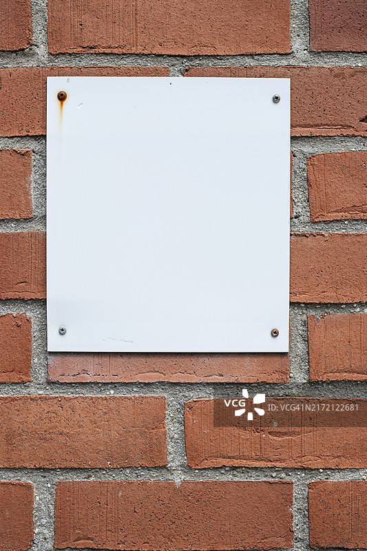 带四个螺钉的砖墙上的白色告示板（带复制空间背景）图片素材