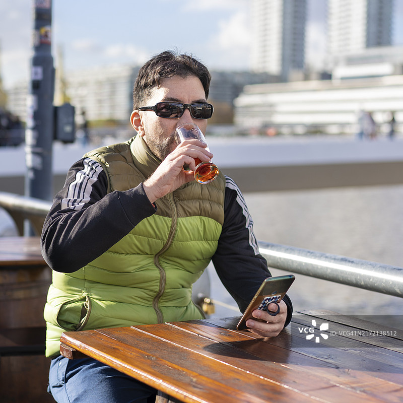 男子坐在港口酒吧里喝啤酒图片素材