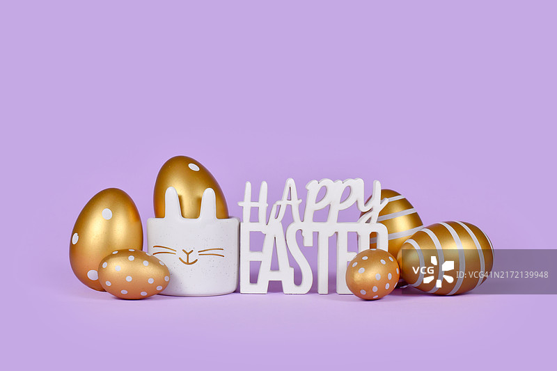 紫色背景上的金色复活节彩蛋和“复活节快乐”字样图片素材