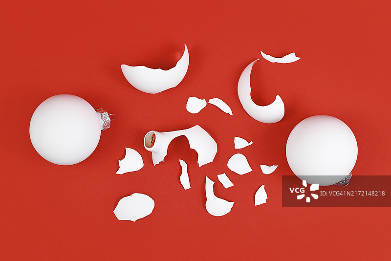 红色背景上破碎的圣诞树玻璃球俯视图图片素材