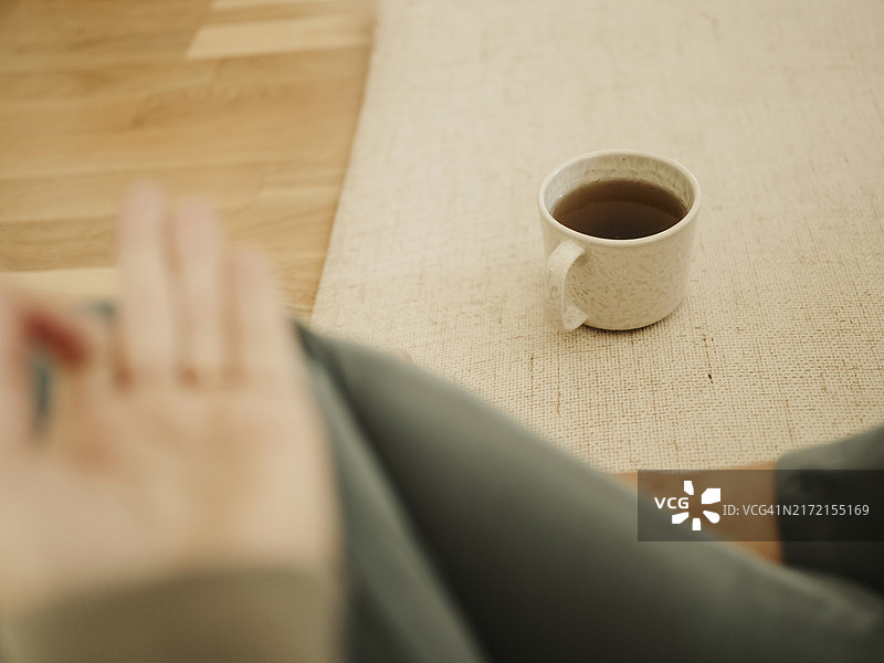 用手印冥想，喝着咖啡放松的女人图片素材