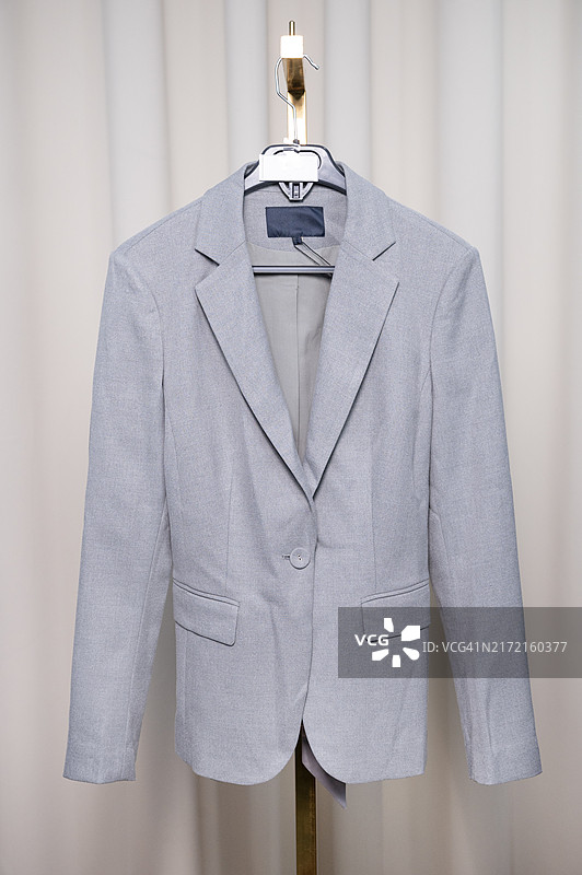 挂在衣架上的浅灰色西装外套图片素材