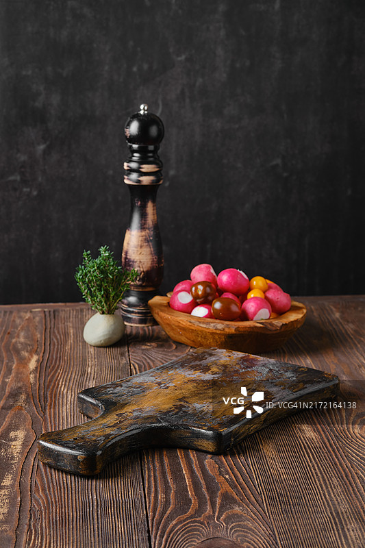 乡村风厨房餐桌，背景虚化，有新鲜蔬菜和胡椒研磨器图片素材