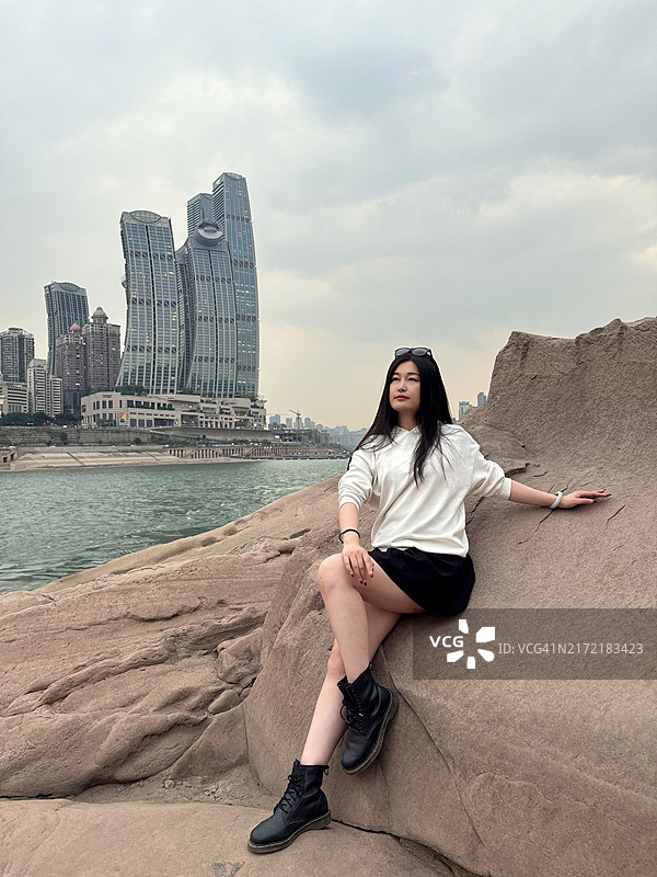 现代城市中拥有城市天际线和摩天大楼的年轻女性图片素材