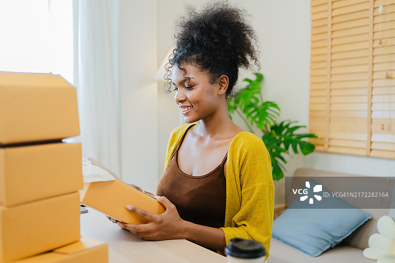 年轻女子在家高兴地打开鞋盒图片素材