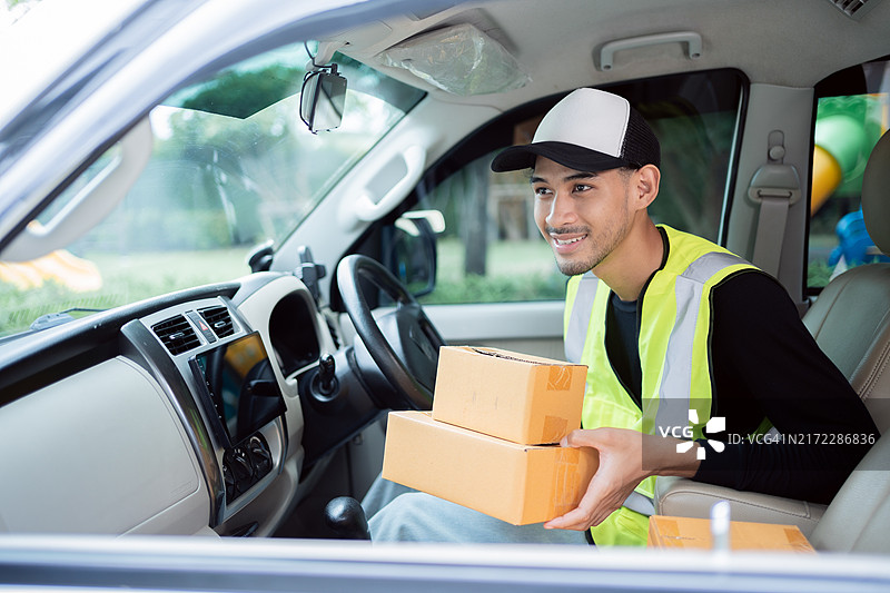 送货员驾驶货车向顾客运送包裹图片素材