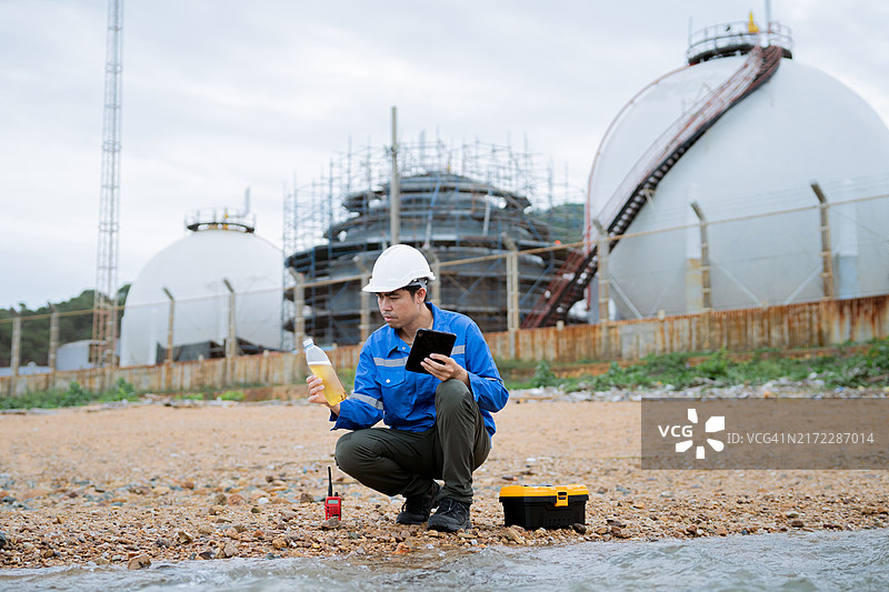 化学工程师在工业区检查并收集废水样本。图片素材