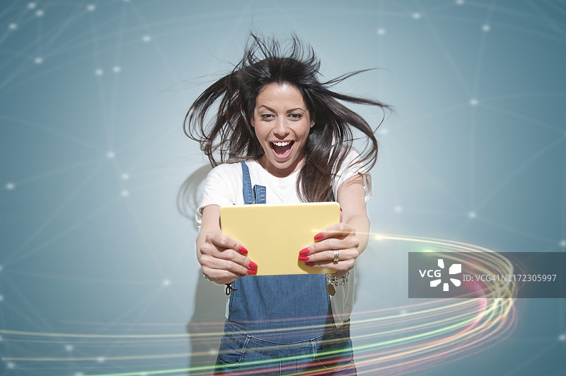 在平板电脑上阅读好消息的兴奋女人图片素材