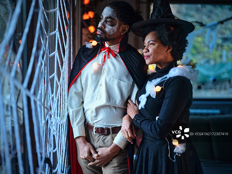 在万圣节服装中，一对黑人情侣在家中做白日梦。图片素材