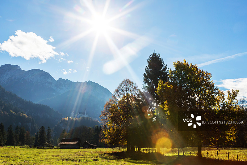 阳光明媚下的新天鹅堡与阿尔卑斯山图片素材