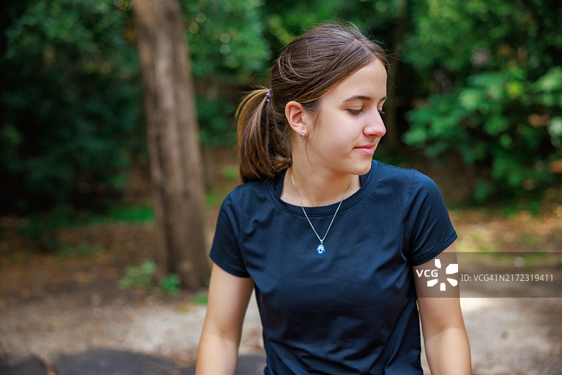 美丽的少女在自然公园享受夏日，目光投向远方。图片素材