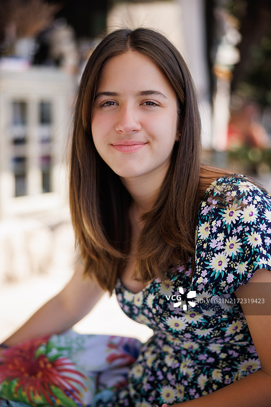 在老城区街道享受夏日的微笑少女肖像图片素材