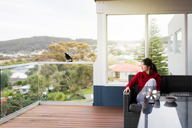 女人在阳台看鸟图片素材