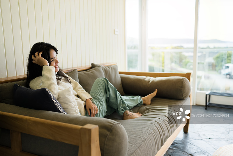 坐在沙发上看向远方的女人图片素材