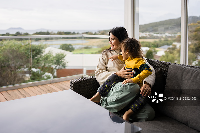 母子坐在阳台的沙发上图片素材