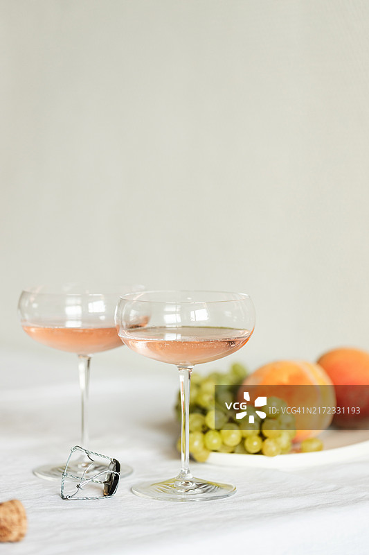 两杯玫瑰香槟和水果盘的静物图片素材