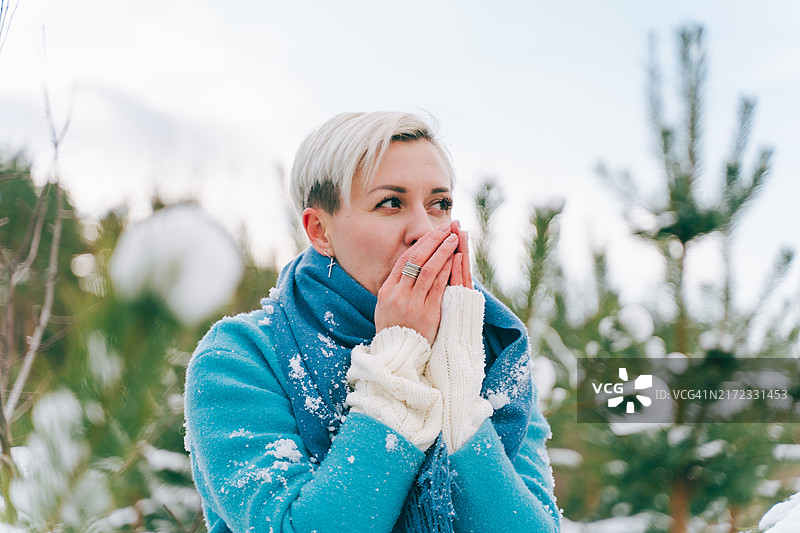 寒冷的步行：女子在公园里寒冷的冬季漫步后瑟瑟发抖图片素材