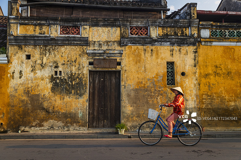 越南会安古镇骑自行车的妇女图片素材