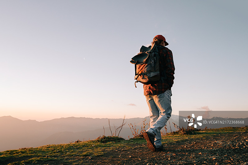 夕阳下山间徒步的男子图片素材