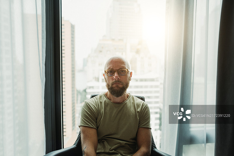 纽约曼哈顿摩天大楼窗边的男人肖像图片素材