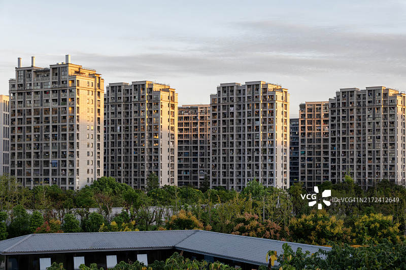 远处夕阳照耀下的高层住宅楼图片素材