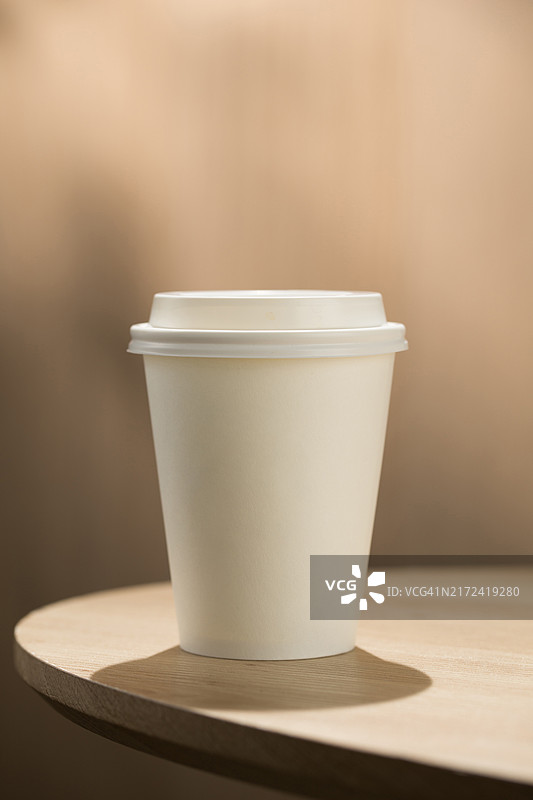木桌上的外带咖啡杯：现代生活的便捷图片素材