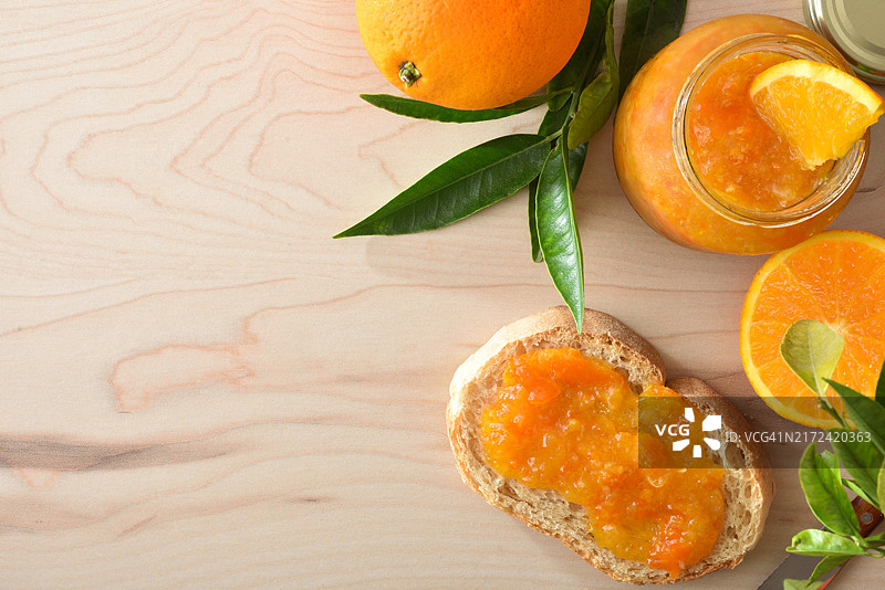 木桌上的罐装橙子酱和吐司图片素材