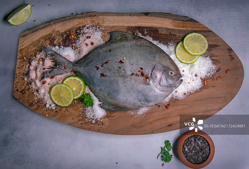 洒盐木板上的黑鲳鱼图片素材