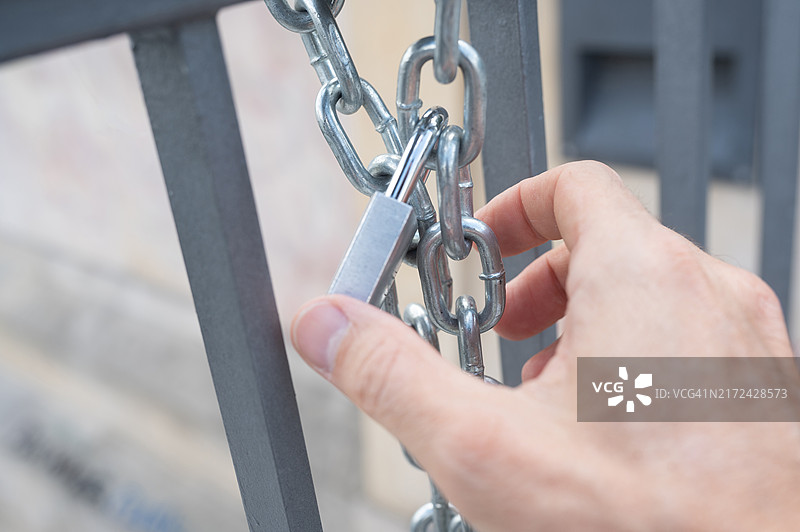 一个人在户外打开/关闭带链子的挂锁图片素材