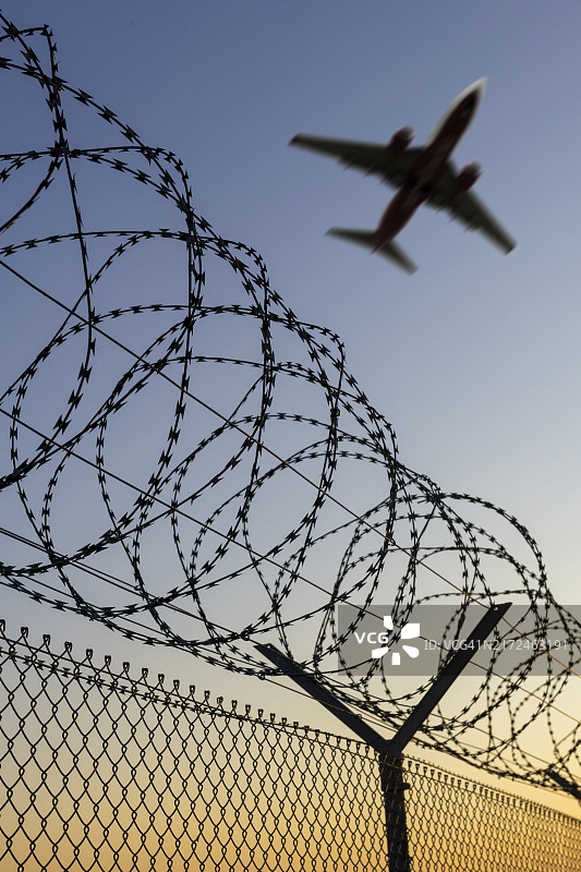 驱逐非法移民象征图像：客机、机场、安全围栏、带刺铁丝网图片素材