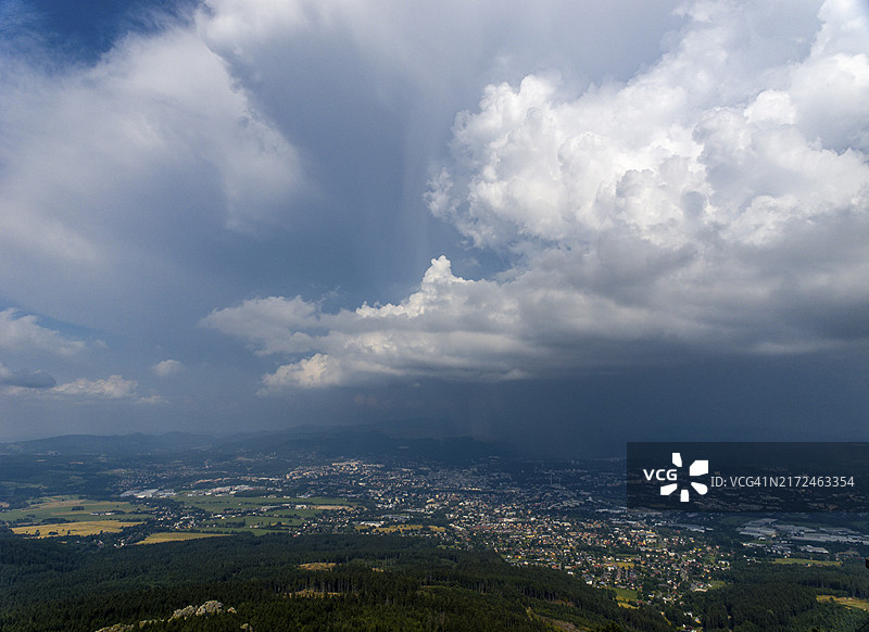 城市和森林上空的风暴云，捷克共和国利贝雷茨的伊泽拉山图片素材