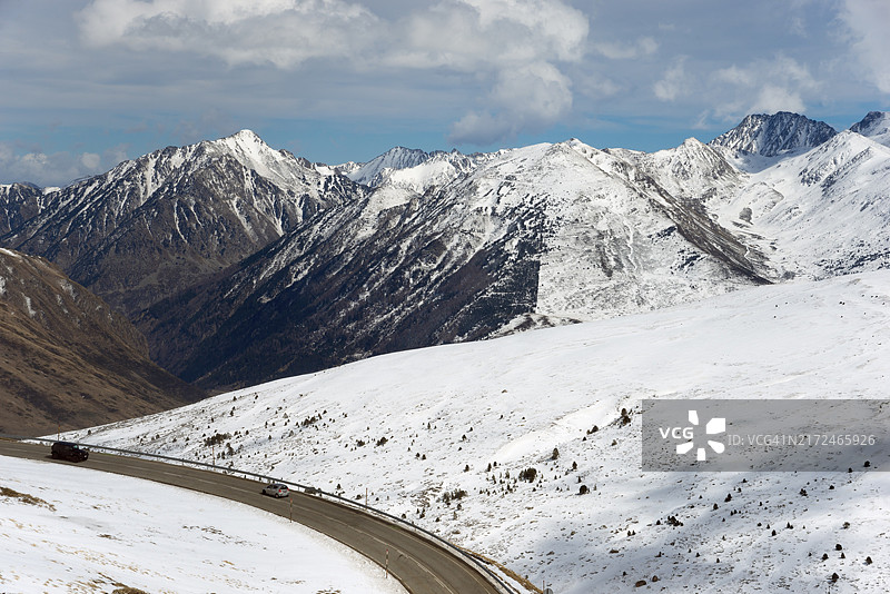 白雪皑皑的山脉和蜿蜒的道路,位于安道尔的冬季景观中,位于东比利牛斯山脉的 El Pas de la Casa 以北,恩坎普,安道尔公国,比利牛斯山脉图片素材