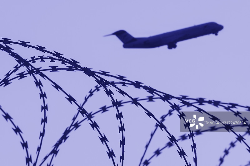 驱逐非法移民象征图像：客机、机场、安全围栏、带刺铁丝网图片素材