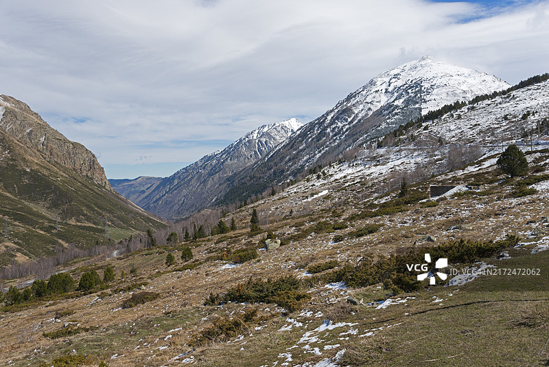 山谷,部分白雪皑皑的山峰和多云天空下的冬季景观,位于 El Pas de la Casa 以北,东比利牛斯山脉,恩坎普,安道尔公国,比利牛斯山脉图片素材
