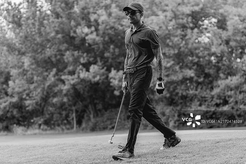 戴手套的高尔夫球手拿着高尔夫球和球座黑白体育摄影图片素材